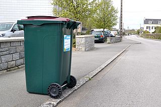 Bac d'ordures ménagères au bord du trottoir